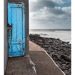 fotografo-puerta-azul-mar-rocas-cielo-nubes-pared-gris.jpg